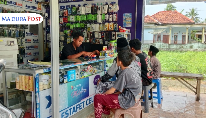 TRANSAKSI. Potret beberapa anak muda sedang melakukan transaksi di konter pulsa dan aksesoris ponsel milik BRILink Estafet Kios milik Abd. Aziz (28). (Istimewa for MaduraPost)