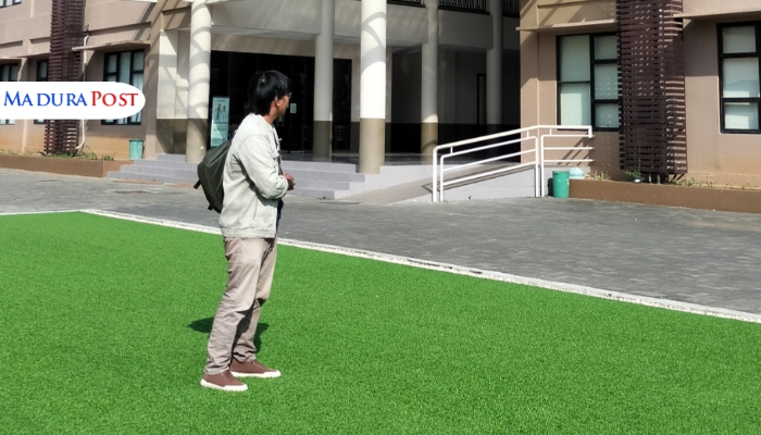 MENATAP. Seorang mahasiswa berdiri di depan Gedung Cempaka, salah satu fasilitas modern di lingkungan kampus UNIBA Madura (M.Hendra.E/MaduraPost)