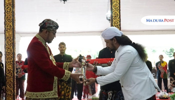 SIMBOLIS. Bupati Sumenep Achmad Fauzi Wongsojudo menerima penyerahan pusaka dari empu Desa Aeng Tongtong dalam prosesi adat di Pendopo Agung Keraton. (Istimewa for MaduraPost)