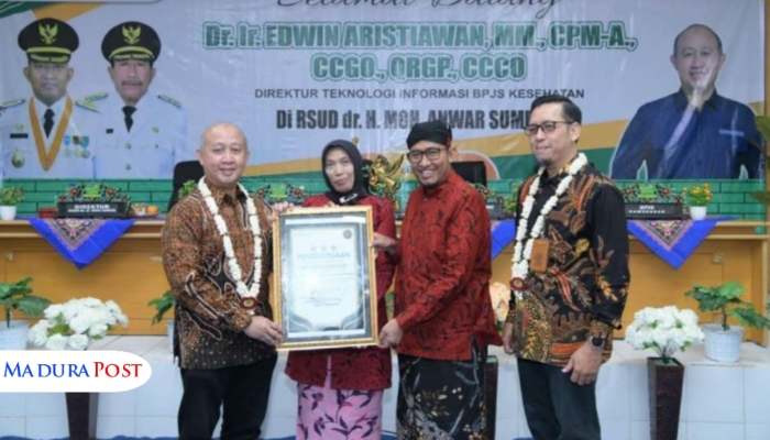 SIMBOLIS. Potret Direktur Teknologi Informasi BPJS Kesehatan, Dr. Ir. Edwin Aristiawan, menyerahkan penghargaan Bintang Tiga Transformasi Digital kepada Direktur RSUDMA Sumenep, dr. Erliyati, disaksikan Bupati Sumenep Achmad Fauzi Wongsojudo. (Istimewa for MaduraPost)