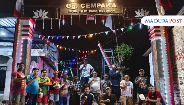 GUYUB. Potret warga RT 005/RW 001, Desa Kebunan, Kecamatan Kota, Sumenep, saat berfoto bersama di depan pintu gerbang Gang Cempaka. (M.Hendra.E/MaduraPost)