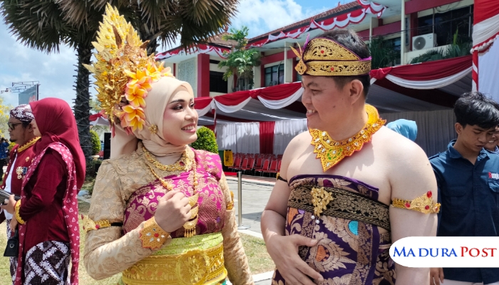 CANDID. Hizbul Wathan, Kabag Hukum Setdakab Sumenep, bersama sang istri tercinta Vety Zurrifatul Laily, tampil serasi dengan balutan busana adat nusantara usai mengikuti upacara bendera HUT ke-80 Kemerdekaan RI di halaman kantor bupati Sumenep. Senyum keduanya memancarkan kehangatan sekaligus kebanggaan terhadap nilai-nilai kebhinekaan. (M.Hendra.E/MaduraPost)