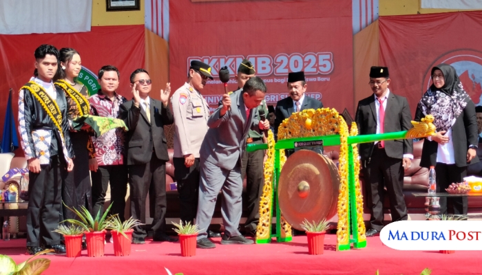 SIMBOLIS. Rektor Universitas PGRI (UPI) Sumenep, Asmoni, saat memukul gong sebagai tanda dimulainya PKKMB 2025, Senin (25/8/2025). (M.Hendra.E/MaduraPost)