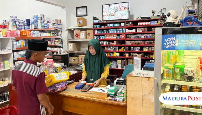 MELAYANI. Seorang pelanggan bertransaksi di Toko SRC Sabira, Agen BRILink milik Kusriyanto di Desa Talang, Kecamatan Saronggi, Sumenep. (M.Hendra.E/MaduraPost)