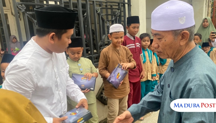 BERBAGI. Ketua PWRI Sumenep menyerahkan paket sarung kepada santri TPQ El-Fath dalam peringatan Hari Santri Nasional 2025, Rabu (22/10/2025). (M.Hendra.E/MaduraPost)