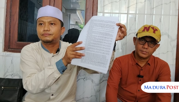 JUMPA PERS. Kamarullah (kanan) menunjukkan dokumen laporan kasus dugaan korupsi yang menjerat kliennya, Mohammad Fajar Satria (kiri), saat konferensi pers di kantor LBH Achmad Madani Putra dan Rekan-rekan, Sumenep. (M.Hendra.E/MaduraPost)