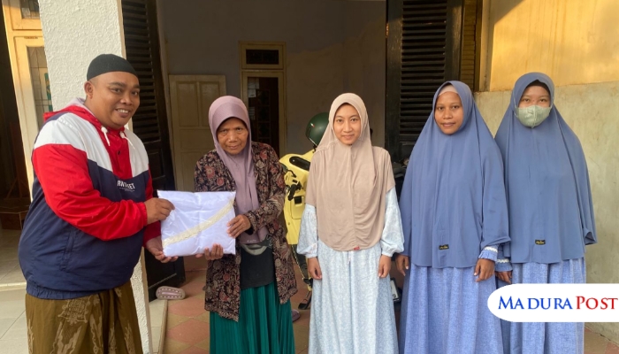 BERBAGI. Anggota DPC PWRI Sumenep, Subaidi Ikshan (kanan), saat menyerahkan bantuan mukena kepada salah satu guru ngaji pada momen peringatan Hari Guru Nasional 2025, di TPQ El-Fath, Sumenep. (Istimewa for MaduraPost)