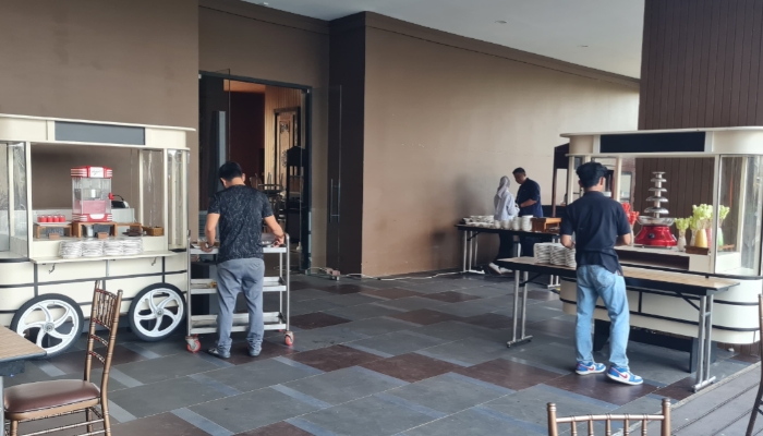 MERAYAKAN. Petugas menyiapkan area festival “Kuliner Lebaran Serba 25K” di poolside MYZE Hotel Sumenep by Artotel, menjelang pelaksanaan acara yang menghadirkan beragam hidangan dengan harga terjangkau bagi masyarakat. (Istimewa for MaduraPost)