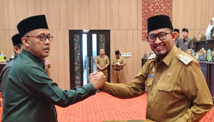 SIMBOLIS. Bupati Sumenep Achmad Fauzi Wongsojudo (kiri), berjabat tangan dengan pimpinan DPRD, H. Zainal Arifin (kanan), usai penandatanganan persetujuan tiga Raperda dalam rapat paripurna, Selasa (7/4/2026). (Istimewa for MaduraPost)
