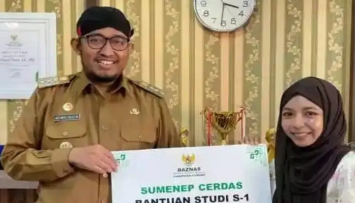 SIMBOLIS. Bupati Sumenep Achmad Fauzi Wongsojudo menyerahkan secara simbolis bantuan studi S-1 program Sumenep Cerdas kepada salah satu penerima. (Istimewa for MaduraPost)