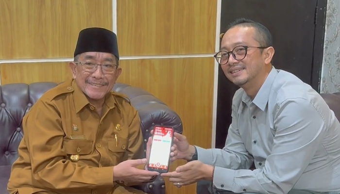 DIPANDU. Pimpinan Bank Jatim Cabang Sumenep, Bambang Eko Budi Prakoso, menunjukkan proses aktivasi JConnect kepada Wabup Imam Hasyim sebagai bagian dari pengenalan layanan digital terbaru. (Istimewa for MaduraPost)