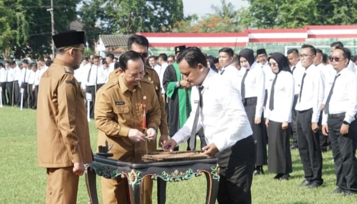 SIMBOLIS. Bupati Achmad Fauzi Wongsojudo, didampingi Kepala BKPSDM Sumenep, Arif Firmanto, saat menyerahkan SK PPPK paruh waktu kepada tenaga honorer di Stadion GOR A. Yani Pangligur, Senin (1/12/2025). (Istimewa for MaduraPost)